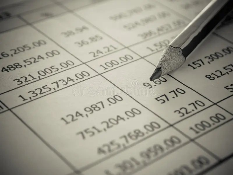 A page of company accounts with a pencil pointing to the figures, representing corporation tax calculations and filing deadlines